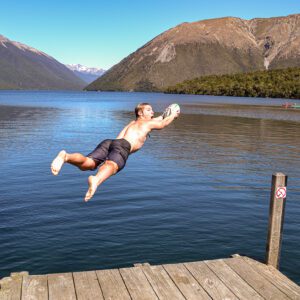 Backpacker hopper i søen i New Zealand