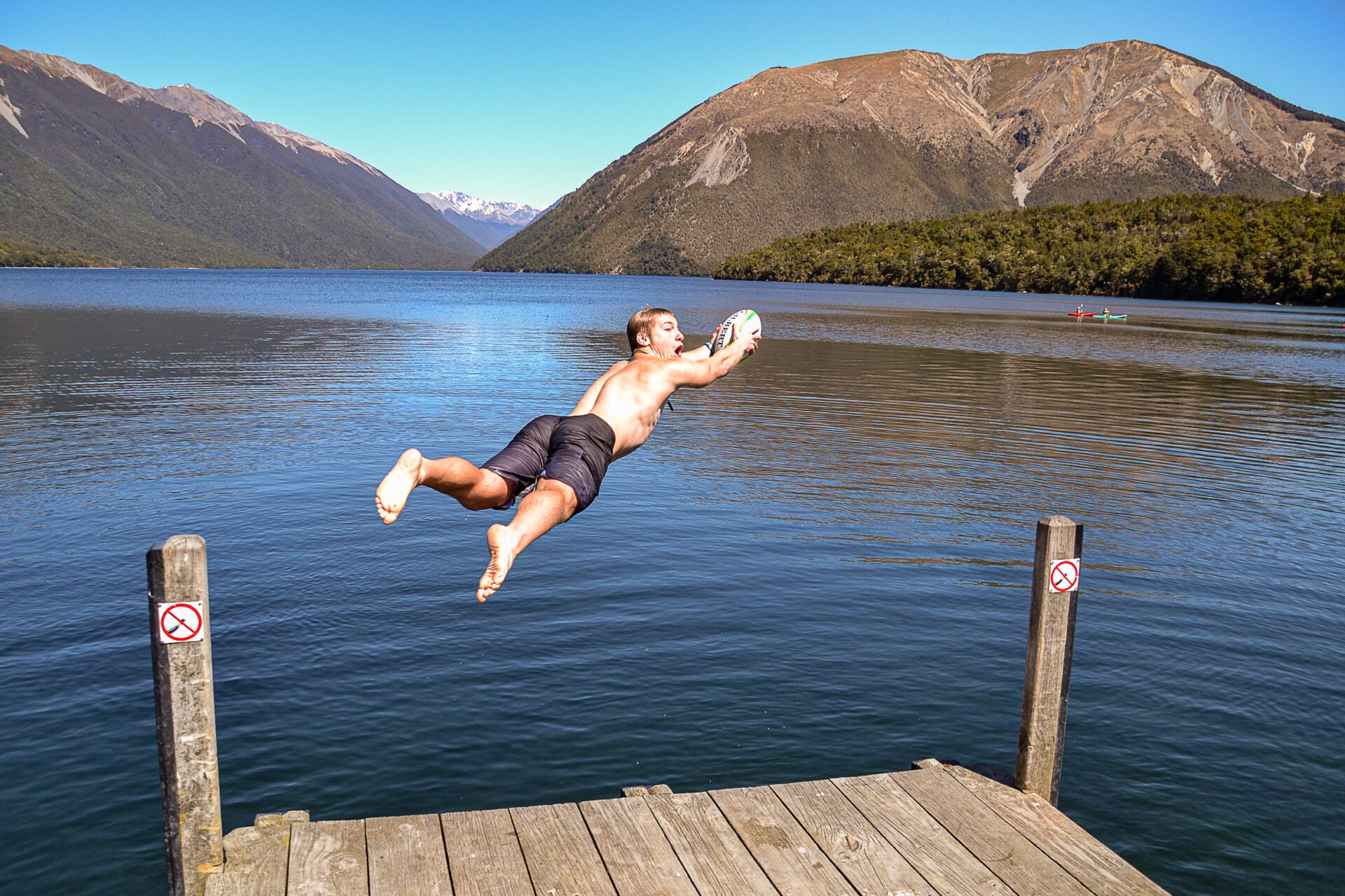 Backpacker hopper i søen i New Zealand