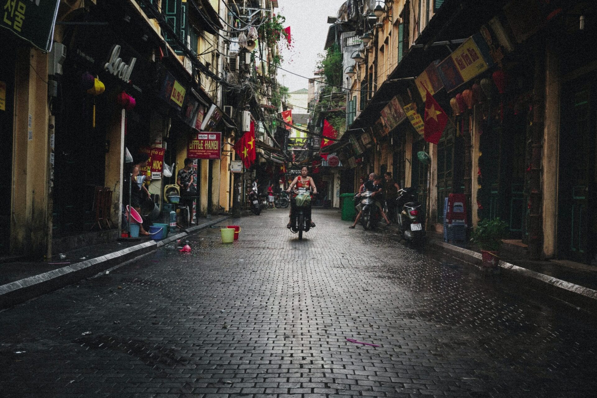 Kvinde på scooter i Hanoi Vietnampå en rolig gade