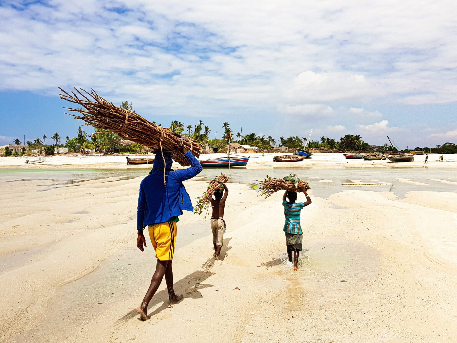 familie går med brænde på stranden i Mozambique
